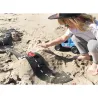 Enfant jouant sur le sable avec un circuit de route flexible Waytoplay King of Road 40 pcs, voitures miniatures sur une piste noire en relief.