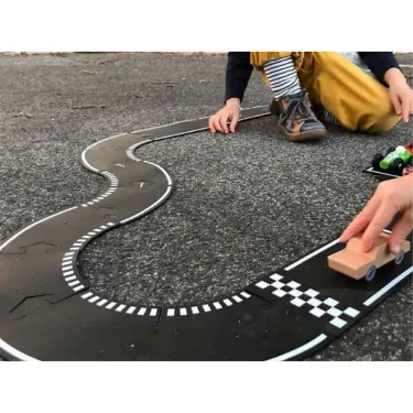 Circuit Grand Prix Waytoplay : coffret 24 pcs, enfant posant une voiture sur piste noire avec virages et damier.