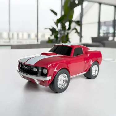 Voiture-jouet Ford Mustang rouge, style race, chromes et bande blanche, vitres noires, design de voiture de sport sur un bureau.
