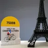 Borne kilométrique Bernard et Eddy avec figurine de cycliste vainqueur maillot tricolore à côté d'une mini tour Eiffel noire.