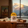 Borne kilométrique colorée D974 « Ventoux » avec petit cycliste miniature sur socle, disposée devant sur une table avec atlas et livre.