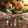 Tubo ASTERIX Village - 7 figurines PLASTOY: personnages en figurine miniatures posés sur une table, avec maisons village gaulois en arrière-plan.