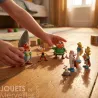 Ensemble de figurines Tubo ASTERIX Village - 7 figurines PLASTOY disposées sur un sol en bois, avec des mains d’enfant agitant les personnages.