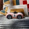 Voiture de course Viglietta Playforever Dottie, véhicule design vintage rose pâle avec numéro 9 sur le flanc et pilote avec casque bronze. Vue de profil.