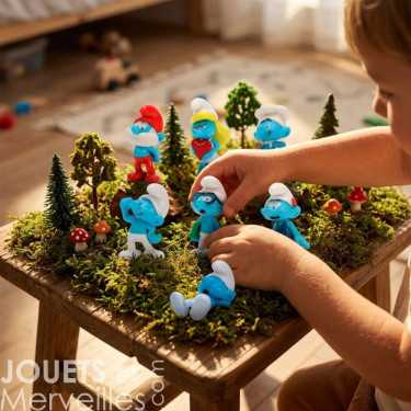 Miniature Schtroumpfs en figurines plastoy sur un décor forestier, enfants manipulant les lutins au milieu des arbres et champignons.