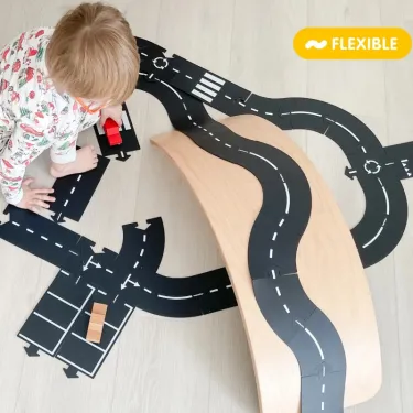Circuit de route flexible Waytoplay, coffret King of Road 40 pcs: enfant joue sur piste noire avec impressions blanches et ponts.