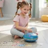 Jeune fille assise par terre, jouant avec un grand tambour à languettes bleu DJECO 6040, notes musicales autour.