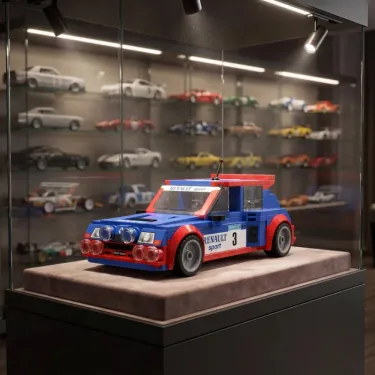 Modèle miniature Renault 5 Maxi Turbo Belu et rouge exposé dans une vitrine sur socle, avec fond de petites voitures en arrière-plan.