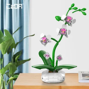 Orchidée CADA 237 pièces, set de construction florale anti-stress: orchidée verte en fleurs roses sur socle blanc, sur une table