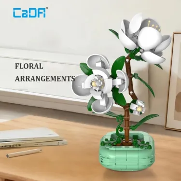 Camellia CADA 301 pièces : set de construction florale décoratif avec arbre en briques mint et fleurs blanches sur socle vert, sur table.