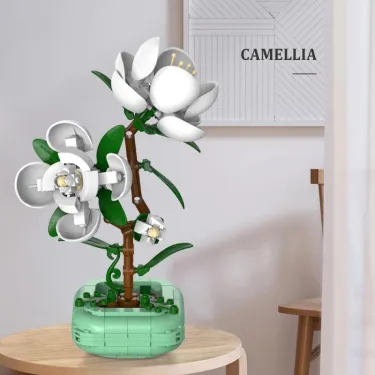 Arbre floral en pièces Camellia CADA, plante avec fleurs blanches sur tronc brun, dans socle vert et base carrée en briques cada.