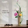 Kit de construction Cada fleurs printemps avec plus de 600 pièces, vase ornemental floral oriental en fleurs multicolores sur socle beige.