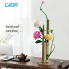 Kit de construction Cada fleurs printemps avec plus de 600 pièces décoratives formant un arrangement floral sur support couleur bois, posé sur une table.