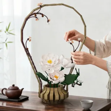 Kit de construction Cada fleurs Hiver: bouquet de camellia blancs en fleurs dans une base géométrique en pièces, entouré d’un cadre floral.