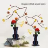 Kit de construction Cada fleurs Automne: deux vases décoratifs avec branches jaillissantes et fleurs orange/jaunes, sur rochers.