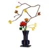 Kit de construction Cada Fleurs Automne avec plus de 750 pièces: vase architectural bleu foncé contenant des fleurs rouges et orange et des branches marron décoratives.