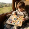 Jeu de labyrinthe à billes magnétique « Cirque » Michelle Carlslund, enfant jouant sur une planche en bois sur un train.