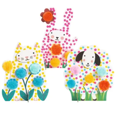 Trois animaux décoratifs en papier posés dans l’herbe: un lapin, un chat et un chien, avec des pompons colorés. Points et pompons - Dans l'herbe DJECO 0965