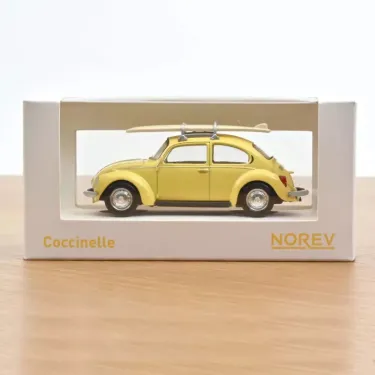Miniature VW Coccinelle 1303 jaune pastel (1973) avec planches de surf sur le toit, dans emballage blanc NOREV 1/43.