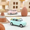 Fiat 500 F 1965 en pastel bleu NOREV 1/43 miniature sur une maquette de ville avec cône de circulation et œuf décoratif.