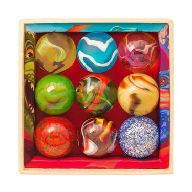 Coffret de 9 billes calots "Dinosaures" Billes & Co, set de billes colorées dans une boîte décorative en carton multicolore.