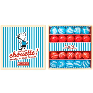 Petit coffret de billes "Le Petit Nicolas" Billes & Co: boîte ouverte montrant des billes bleues et rouges décorées dans des rangées.