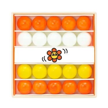 Petit coffret de billes "Fleur" Billes & Co: billes orange, blanche et jaune rangées en lignes dans un coffret en carton.