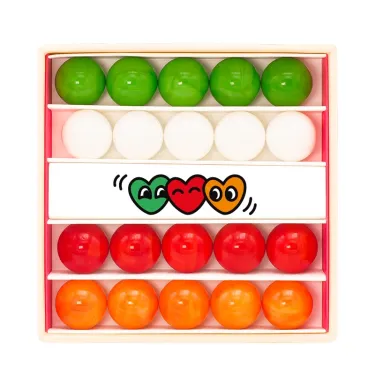Petit coffret de billes colorées classées par rangées: vertes, blanches, rouges et oranges, avec dessin de trois cœurs au centre.