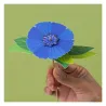 Petite main tenant un bâtonnet avec une grande fleur bleue en papier, kit créatif “3 fleurs des champs à créer” Pirouette Cacahouète.