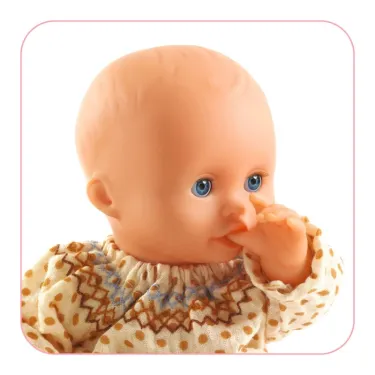 Poupée Baby Iris POMEA de Djeco 7879 : visage de bébé sans cheveux aux yeux bleus, doigt en bouche, vêtue d’un pull imprimé à pois et motif jacquard beige.