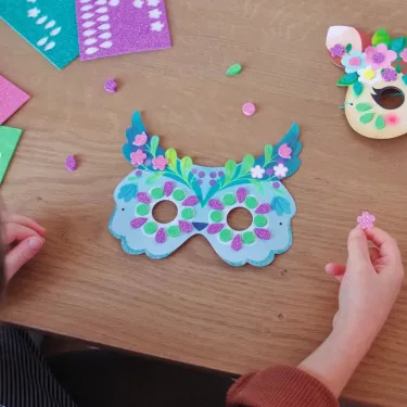 Masques mosaïques décoratifs “Animaux de la forêt” DIY DJECO 7936 avec masque bleu orné de fleurs et feuillages, décoré à la colle pailletée.