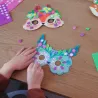 Masques mosaïques à décorer « Animaux de la forêt » DIY DJECO 7936 : enfants posant des motifs floraux et paillettes sur deux masques colorés.