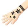 Tatouages Polynésie DJECO 9248: motif tatouages noir gravés sur le poignet et la main d’un dessin simple, soleil, coquillage et figure humaine sur fond peau pale.