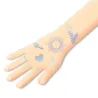 Tatouages éphémères « Lucky charms » DJECO 9596 sur avant-bras, motifs cœur, soleil et feuillage bleus pastel.