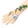 Tatouage temporaire tatoué sur l’avant-bras: crâne et os, palmier, gobelet, éclairs et étoiles typiques du design Tatouages Bang Bang DJECO 9577.