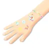Tatouages temporaires Sakura DJECO 9619 décorant le poignet et le dos de la main avec des motifs colorés de fleurs, papillons et voiles de bateau.