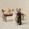 Couple de souris mariés dans leur coffret Maileg, les deux se serrent dans une étreinte près d’un gâteau nuptial sur un présentoir.
