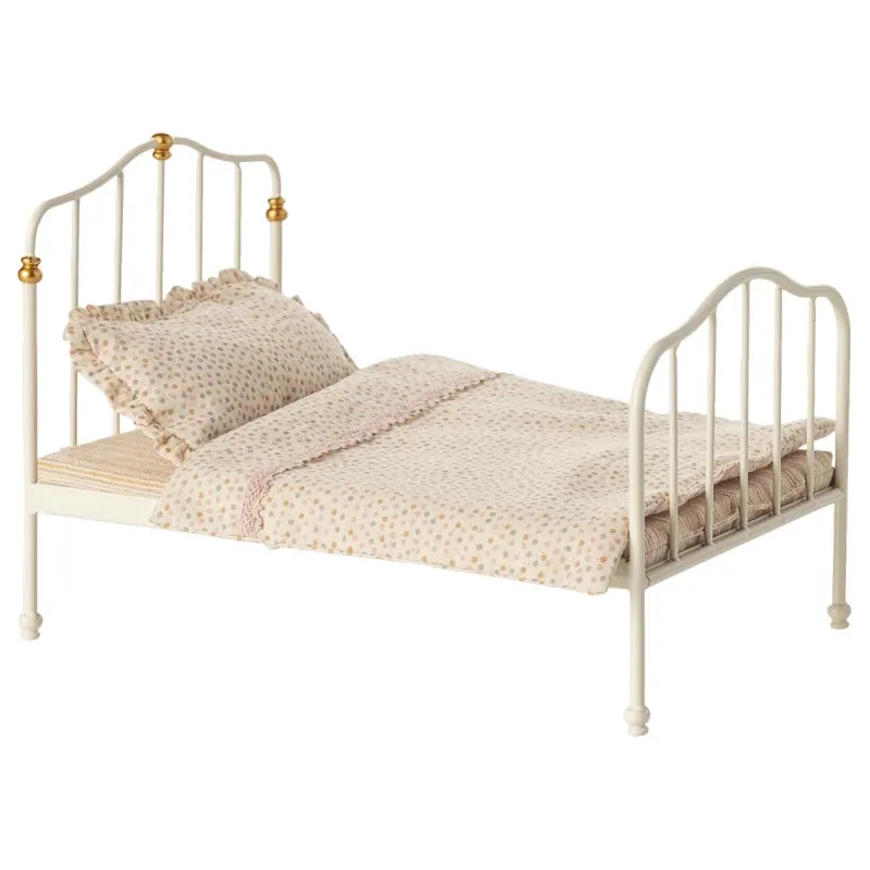 Grand lit double vintage en métal blanc pour souris Maileg avec drap et couverture à motifs pastel et oreillers.