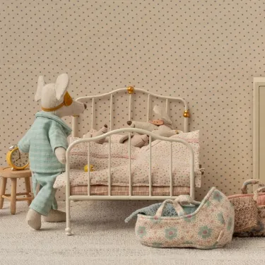 Grand lit double vintage en métal blanc pour souris Maileg, décor percale à pois avec peluches et valisette en tissu pastel dans une chambre douillette.