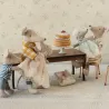 Gâteau de fête pour souris Maileg sur socle, entouré de souris en tenues délicates autour d’une table miniature.