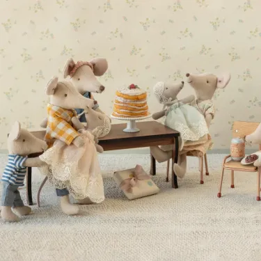 Souris Maileg en robe rose poudré entourée de la famille autour d’un gâteau sur pied, décor rétro et table en bois.