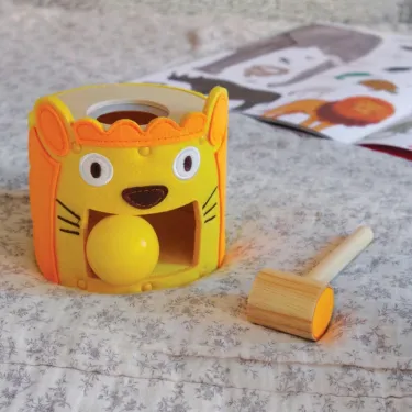 Tambour en forme de lion avec balle jaune et maillet en bois, jeu de tap-tap SoftiTap DJECO 6490.
