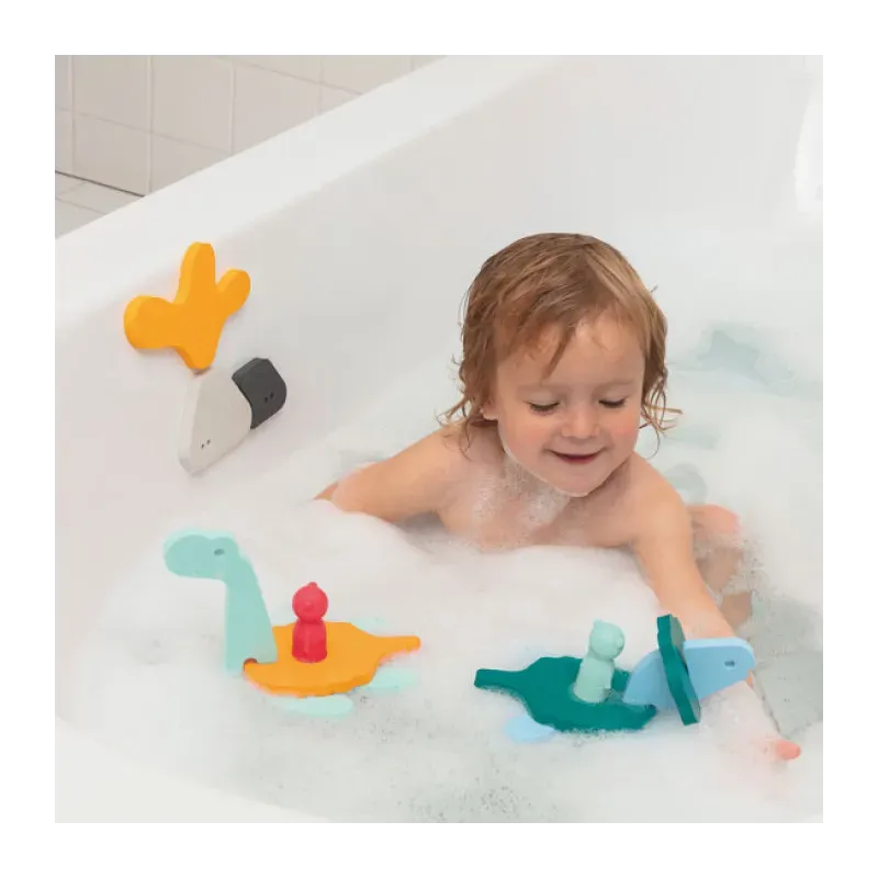 Bébé jouant dans le bain avec des jouets flottants colorés en forme de animaux et personnages. Bébé jouant dans le bain avec des jouets flottants colorés en forme de animaux et personnages.