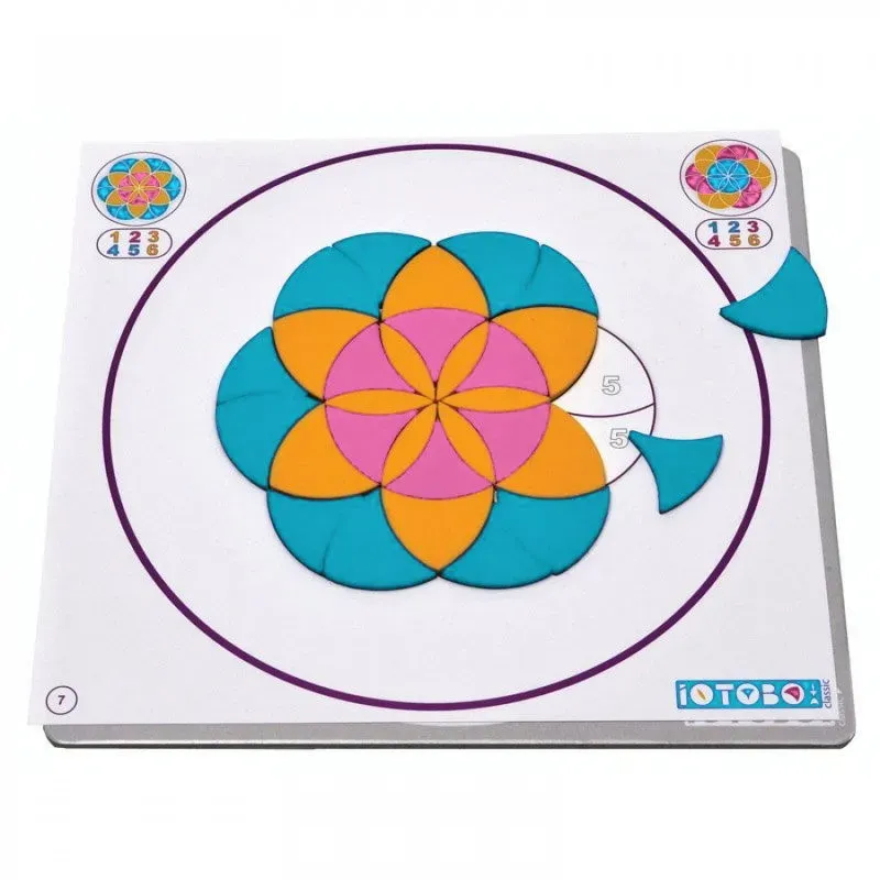 Plateau de jeu en forme de mandala coloré avec pièces amovibles turquoise, orange et pink, et cercle guide violet.