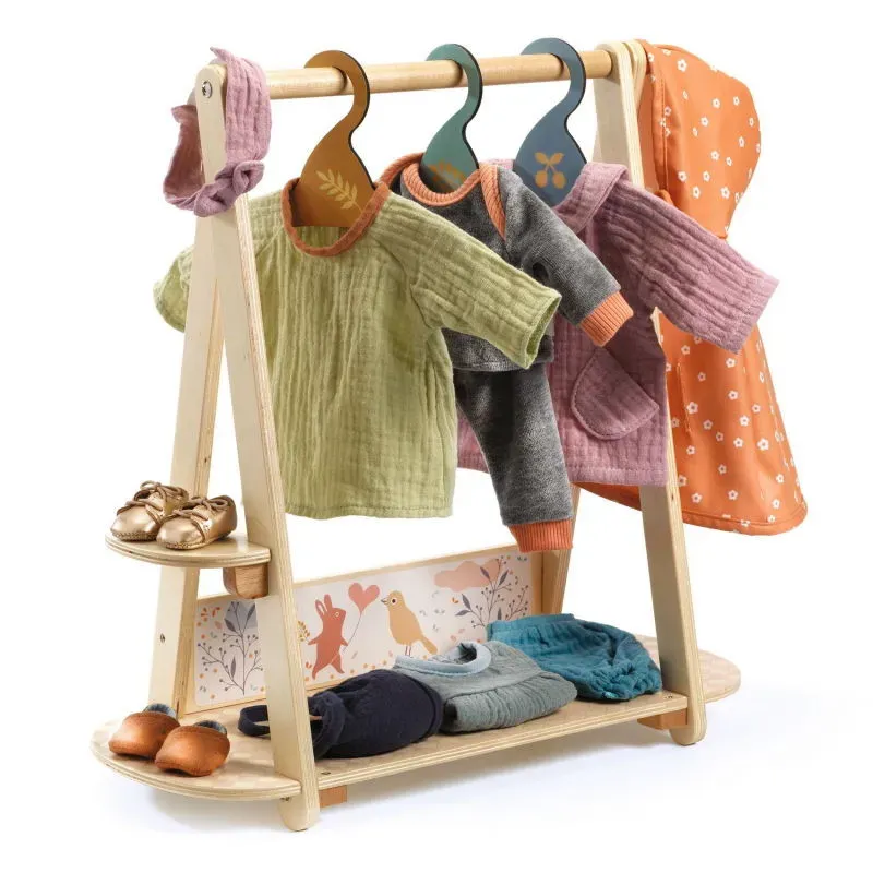 Portant en bois pour vêtements de poupee: chemises, cardigans colorés, ponchos et chaussures sur les étagères, motif floral en bas. Portant en bois pour vêtements de poupee: chemises, cardigans colorés, ponchos et chaussures sur les étagères, motif floral en bas.