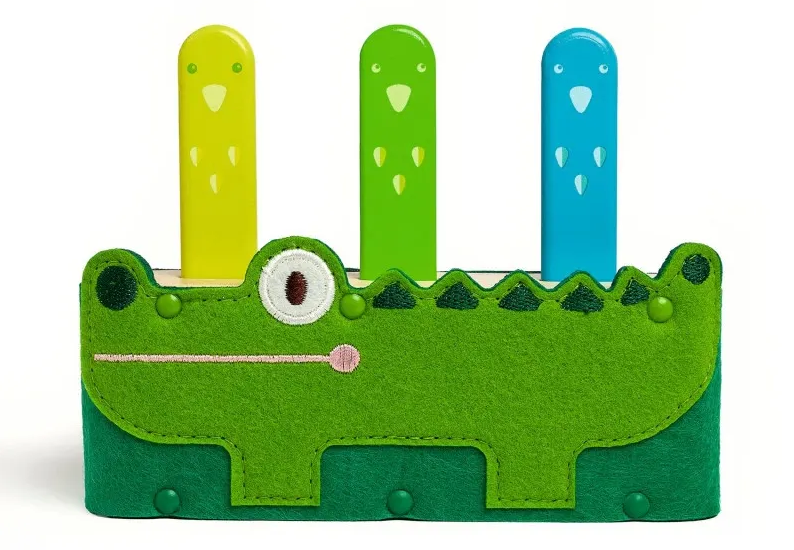 Porte-stylo crocodile vert en feutre avec trois personnages colorés jaunes, vert et bleu and croc dans le style ludique. Porte-stylo crocodile vert en feutre avec trois personnages colorés jaunes, vert et bleu and croc dans le style ludique.