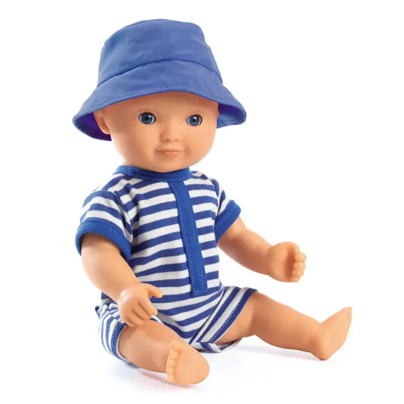 Poupée Baby Poméa garçon en maillot rayé bleu et blanc et chapeau bleu, assis les jambes posées. Poupée Baby Poméa garçon en maillot rayé bleu et blanc et chapeau bleu, assis les jambes posées.