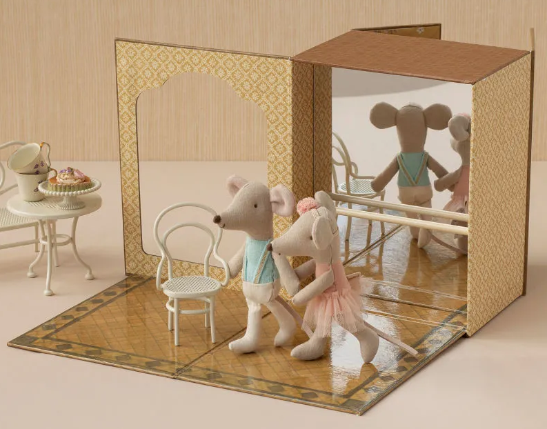 Studio de danse miniature: deux figurines souris Maileg en tutus jouent sur un parquet décoré, avec un décor en carton et miroir, et petit mobilier de scène.